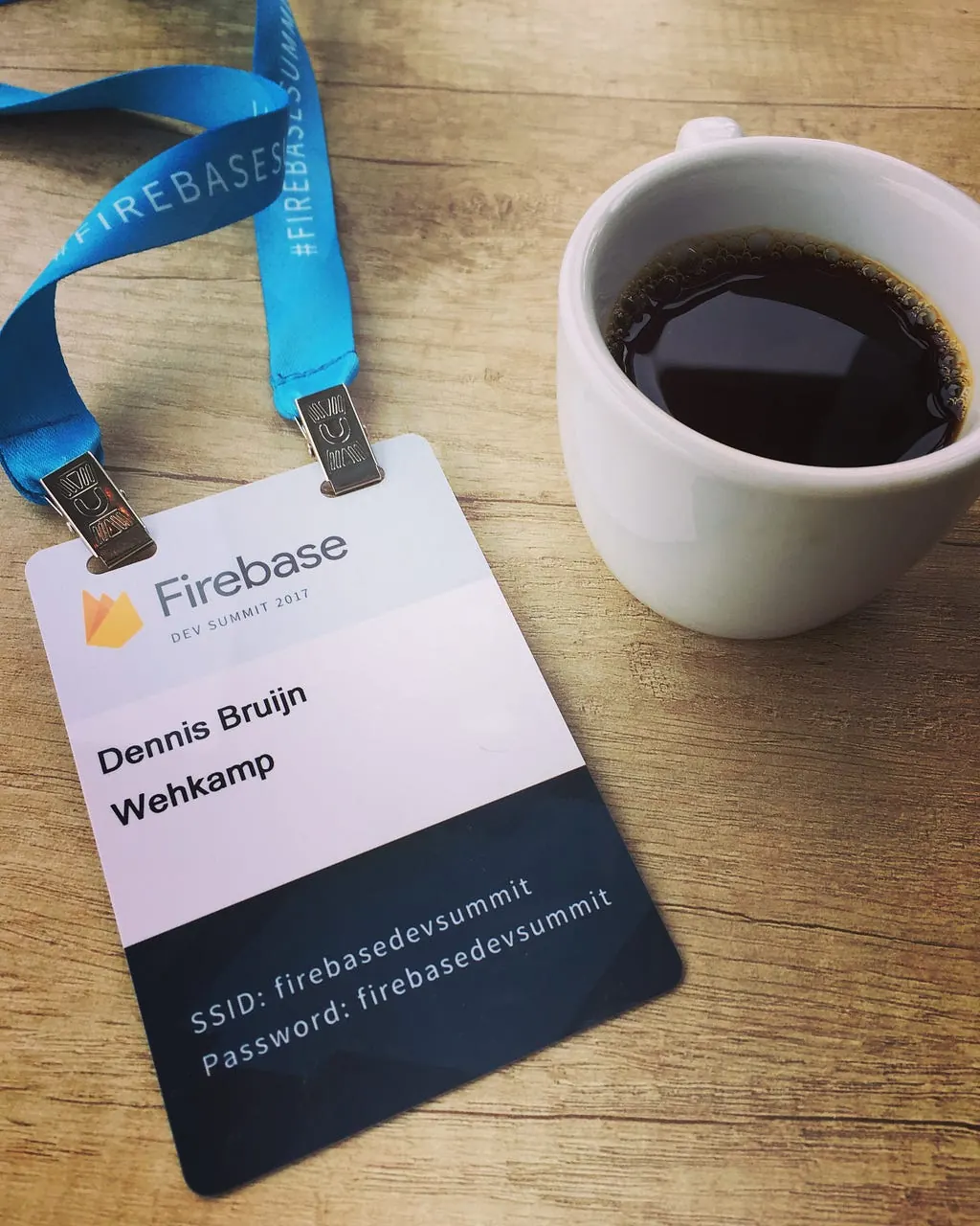 Firebase Dev Summit 2017 attendee badge next to a cup of coffee